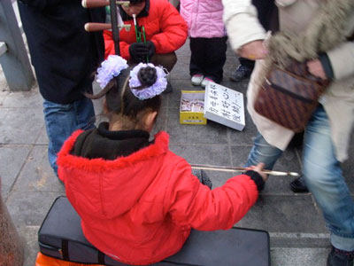 子供が二胡を演奏して通りゆく人に餞別を求めるのは珍しい